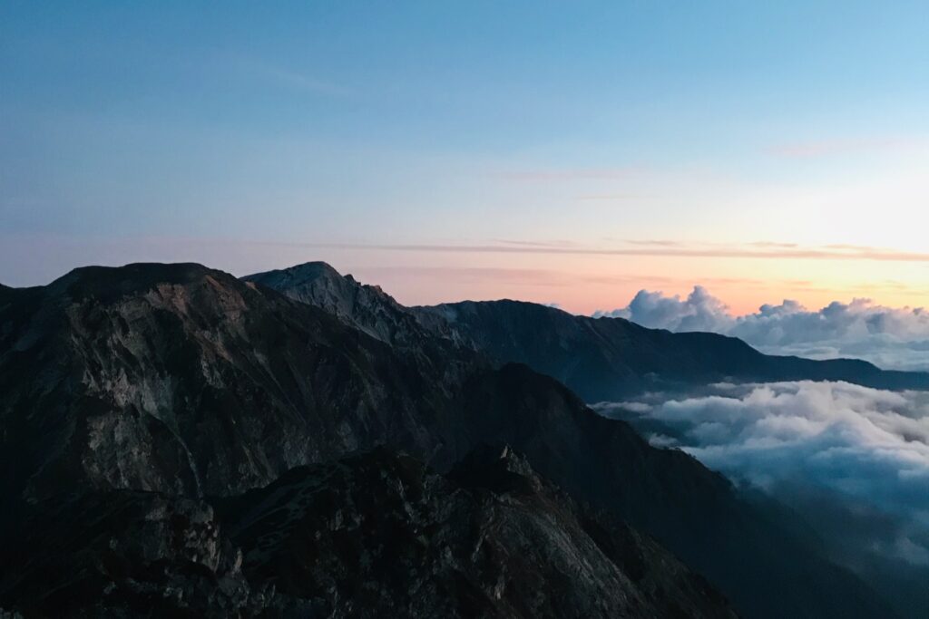 夜明け前の薄明かりに浮かぶ山々と雲海