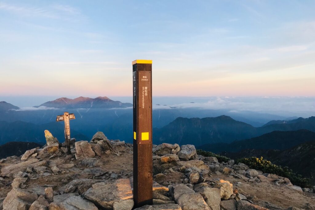 唐松岳山頂の標柱と夜明けの空