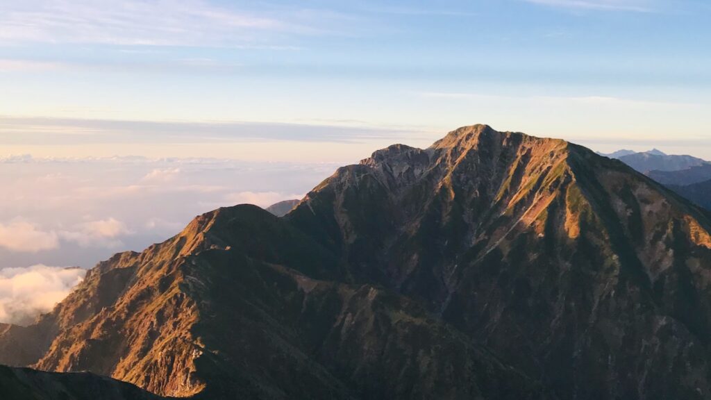 唐松岳山頂から望む朝日に照らされた五竜岳