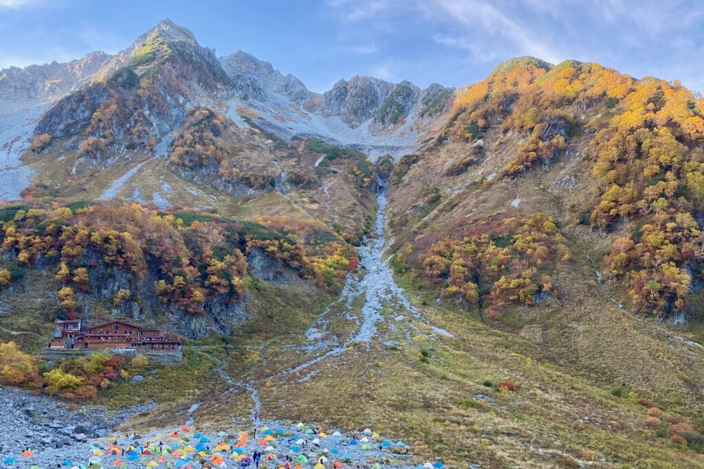 紅葉の涸沢カールを見上げる。中腹に涸沢ヒュッテが建つ