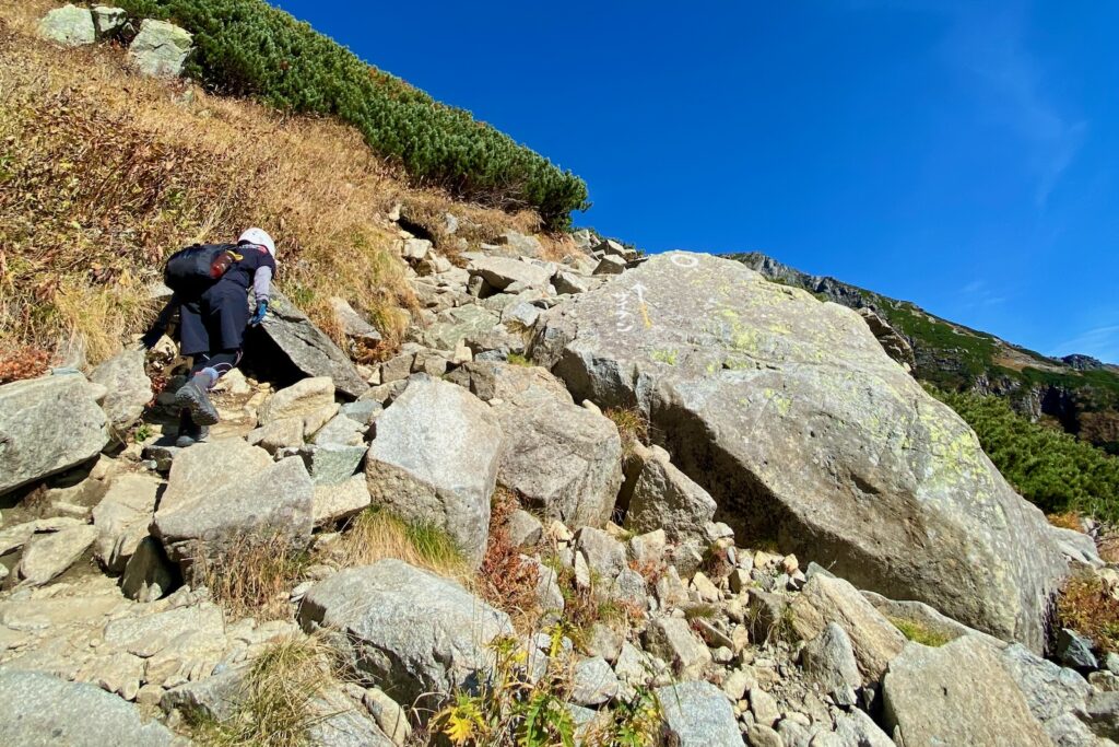 ザイテングラートの岩場を手を使って登る登山者