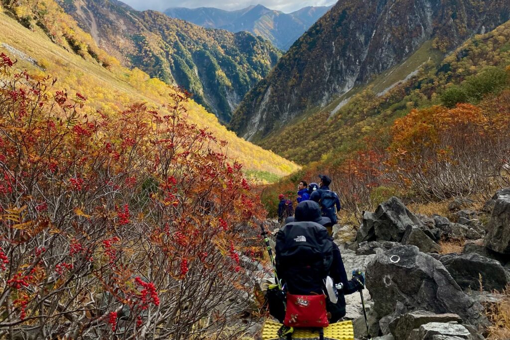 紅葉の登山道を下山する登山者たち