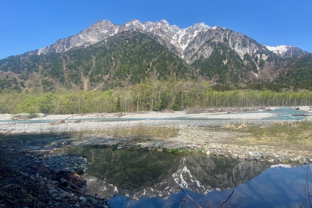 梓川の河原の水たまりに映る明神岳と新緑