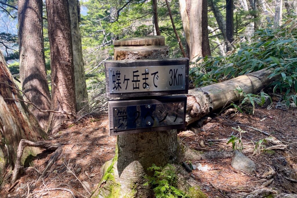 蝶ヶ岳まで3kmを示すベンチ横の標識
