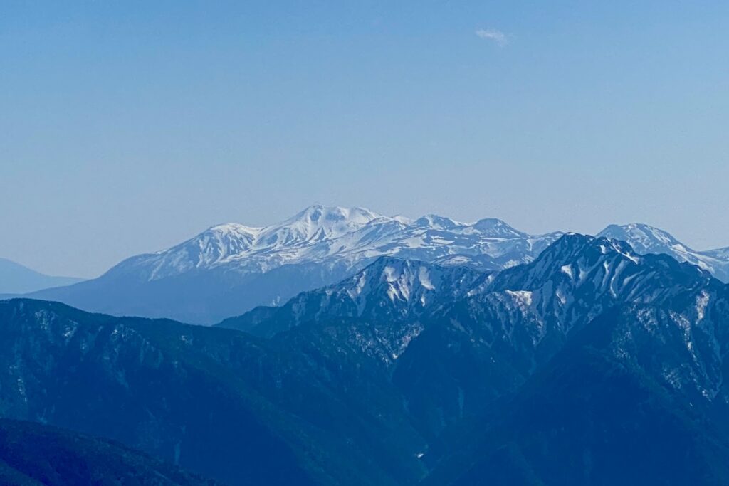 蝶ヶ岳の稜線から遠くに望む残雪の山並み