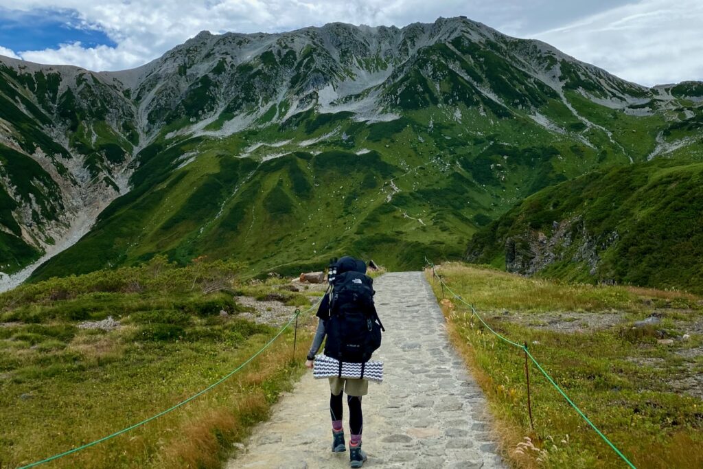 立山を正面に望みながら石畳の道を歩く登山者