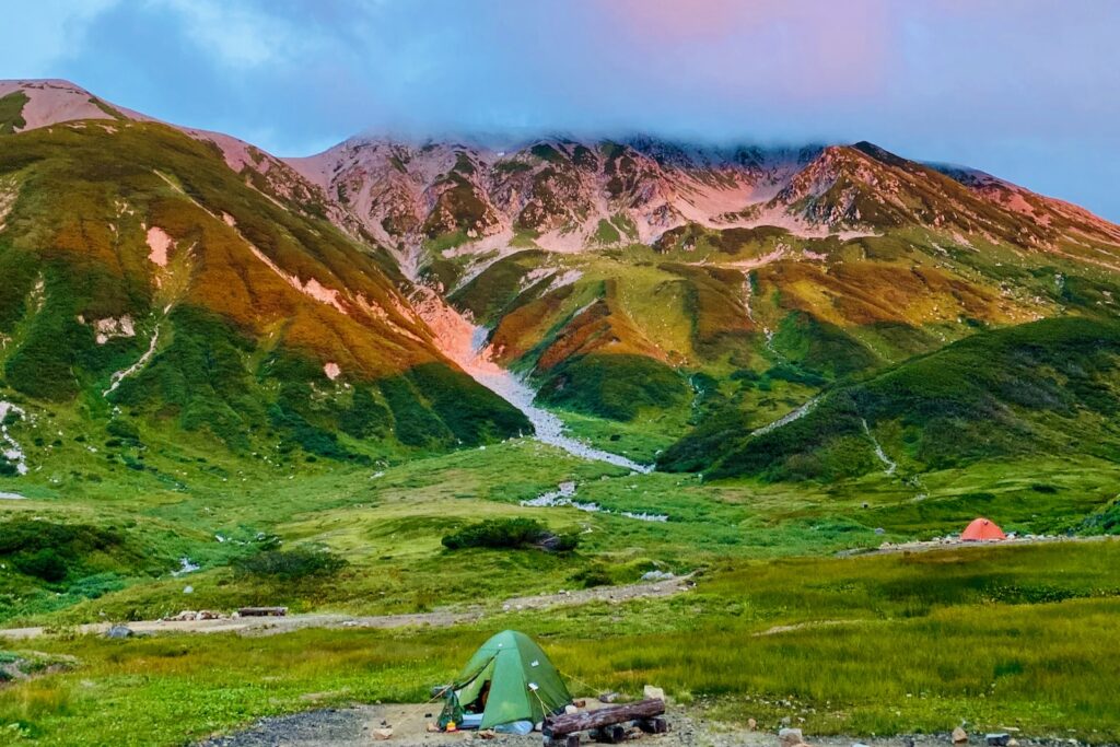夕日に赤く染まる山肌と山にかかる雲
