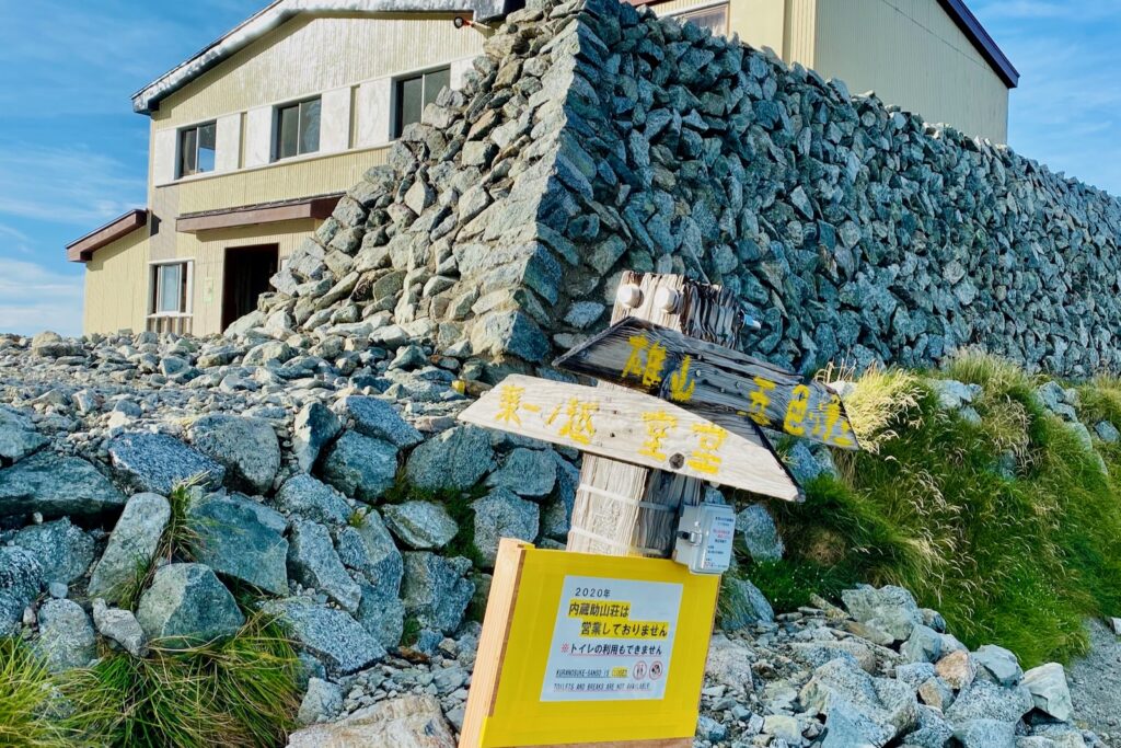 一の越山荘の建物と雄山・室堂方面を示す道標