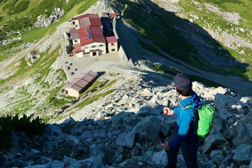 一の越山荘を眼下にガレ場の急登を登る登山者